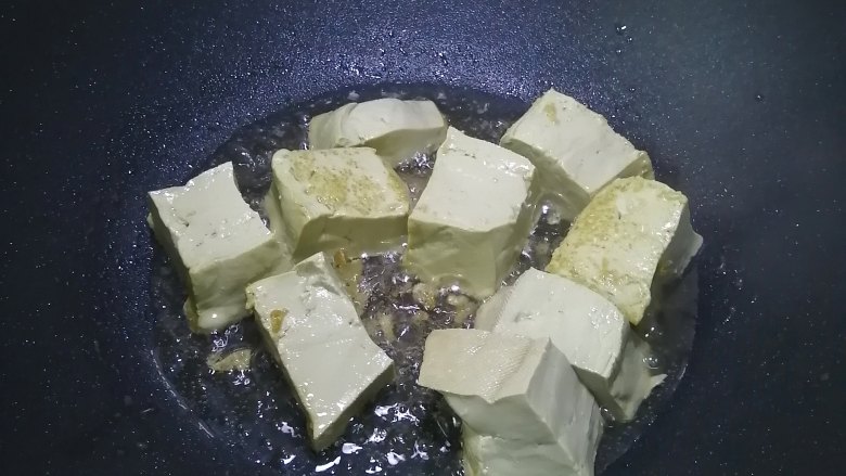 金针菇豆腐煲,热锅入油,加入豆腐煎至四面焦黄