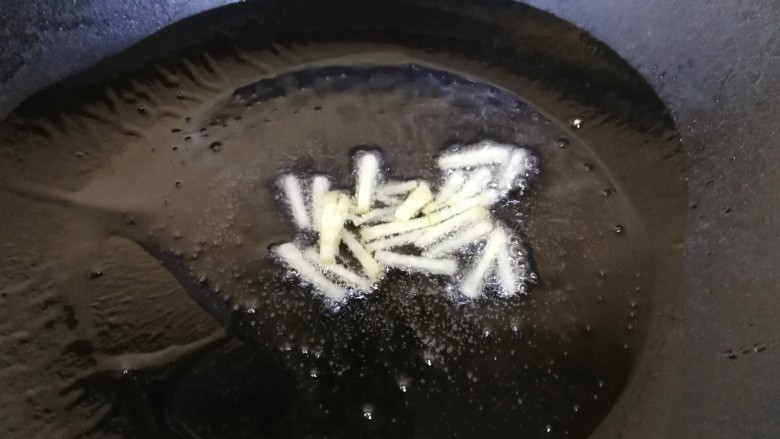西葫芦炒腊肠,热锅凉油,放入姜丝炒香。