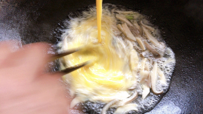 平菇鸡蛋汤,边倒入锅中,边搅拌均匀。
