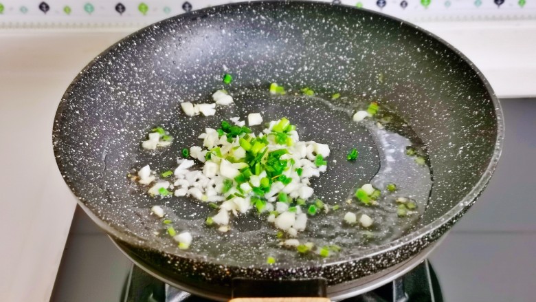 金针菇豆腐煲,另起油锅加入葱花,蒜末炒香。