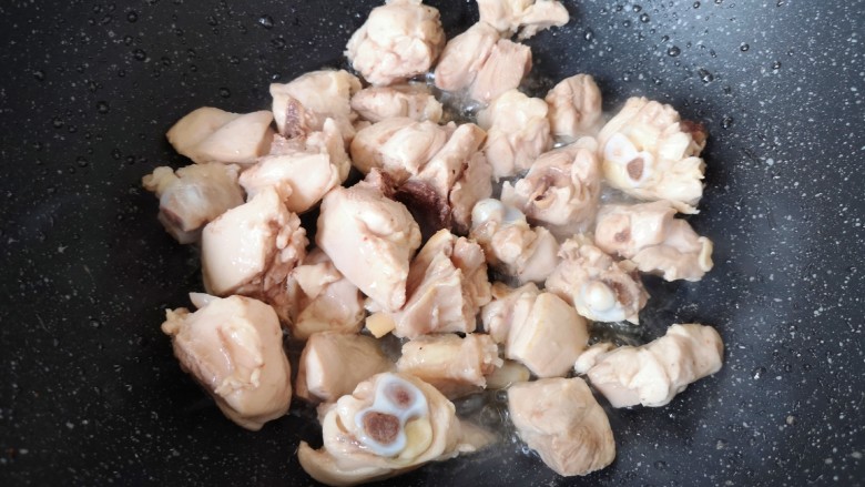 香菇炖鸡腿,炒锅内倒适量的食用油烧热,下入鸡腿块。