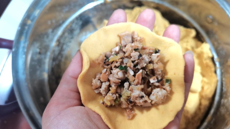 番薯黄夹,取一小块压成薄饼,放入馅料两边对折包拢,边缘压实