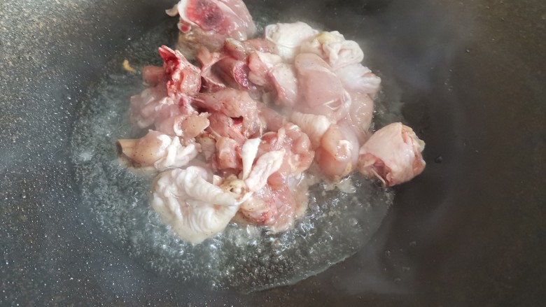 香菇炖鸡腿,起锅烧油,下入鸡肉块翻炒至变色