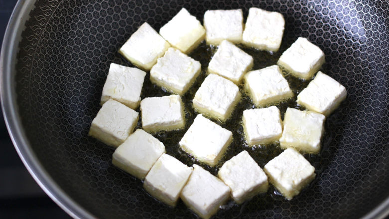 金针菇豆腐煲,油锅烧热后,放入豆腐小火慢慢煎至。