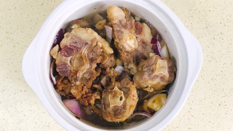 酱烧牛骨,翻炒均匀后,倒入慢炖锅里