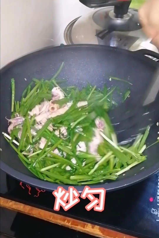 韭菜炒鱿鱼,炒匀至熟