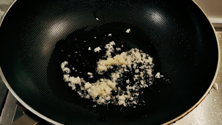 清炒苦瓜,起油锅放入食用油,油热后放入蒜碎炒出香味。