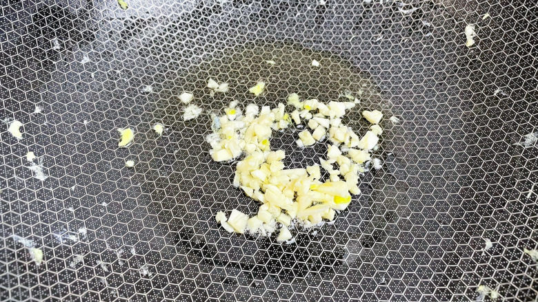 金针菇炒鸡蛋,原锅倒入适量的食用油烧热,放入蒜末爆香