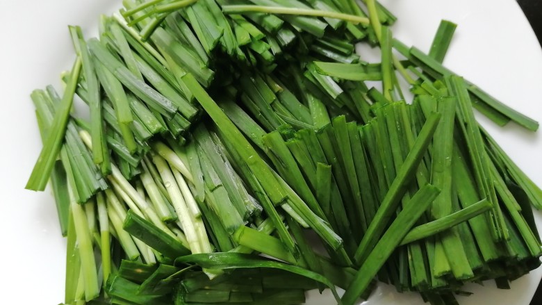 韭菜炒蚕豆,将韭菜切成均匀的段状