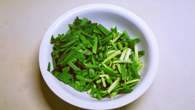 韭菜炒鱿鱼,切小段,菜梗菜叶分开放。
