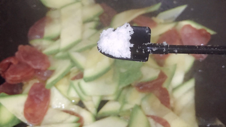 西葫芦炒腊肠,开盖,加入适量盐