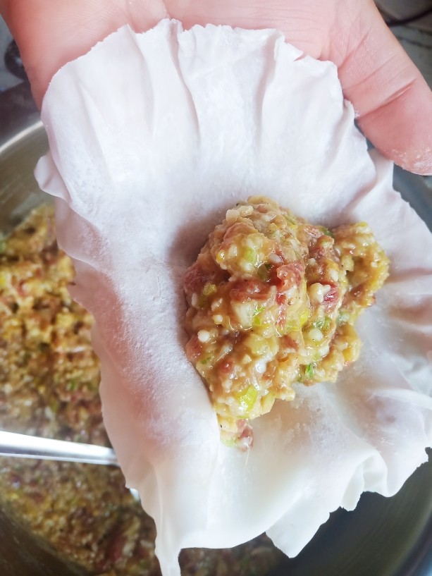 内蒙特色美食——稍美,取一张烧麦皮,放上适量的馅料。
