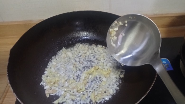 葱油花蛤,油锅下香葱油,放入生姜,大蒜末爆香