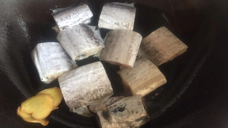 红烧带鱼,将生姜片放一边,下入带鱼稍微煎一下