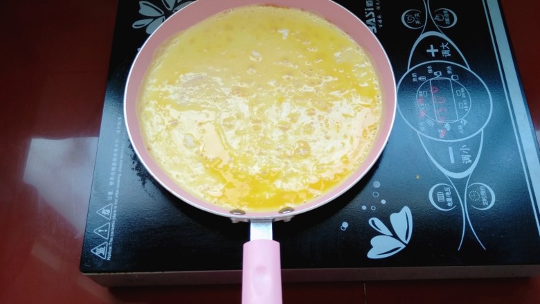 肉馅鸡蛋卷,开始煎鸡蛋了,把蛋液倒入锅里小火慢煎