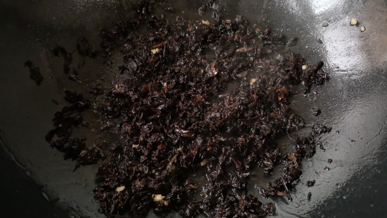 梅干菜肉饼,将泡发好的梅干菜攥去水后倒入锅中,中火翻炒出香味。