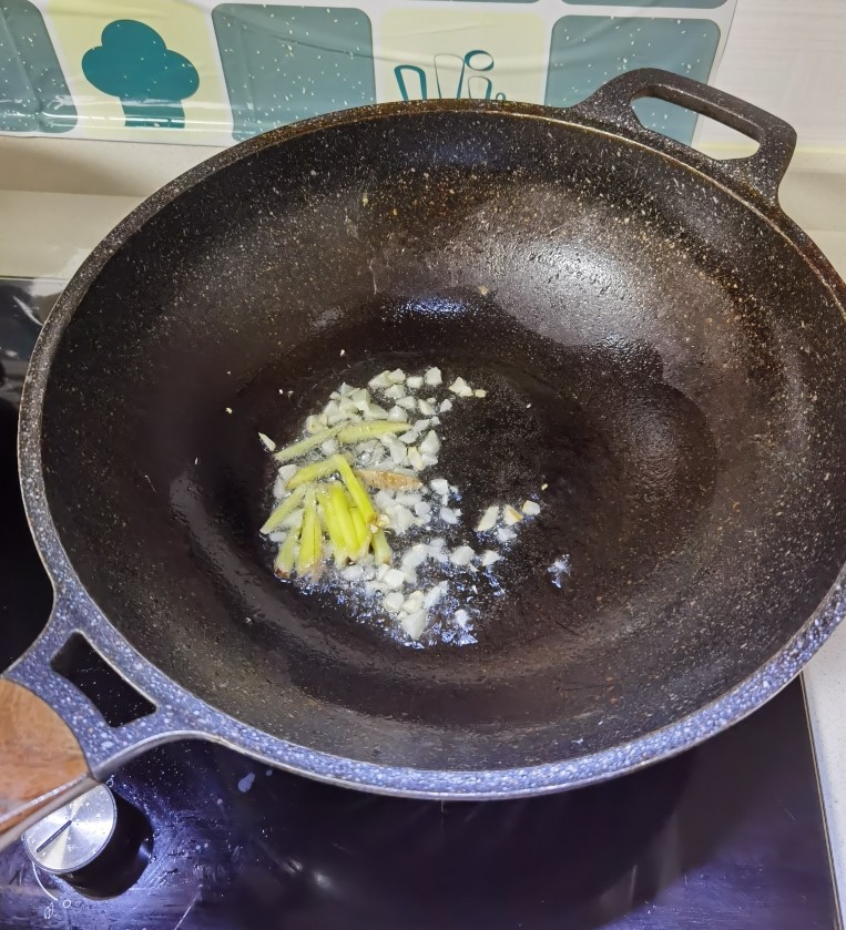 葱油花蛤,热锅下油,倒入姜蒜爆香