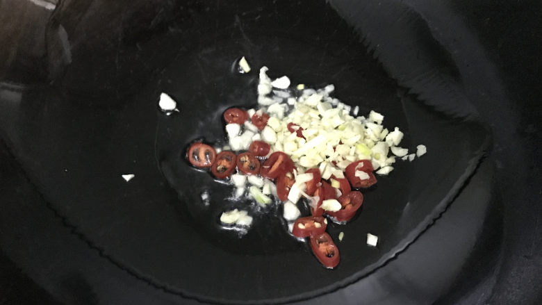 蚝油油麦菜,另起锅,烧热倒油,下入蒜末和辣椒圈,小火炒出香味