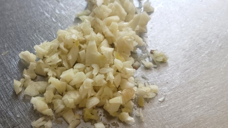 茄子盖浇饭,蒜拍散后再剁成末。大蒜经过挤压味道挥发出来,而且大蒜素更好出来。