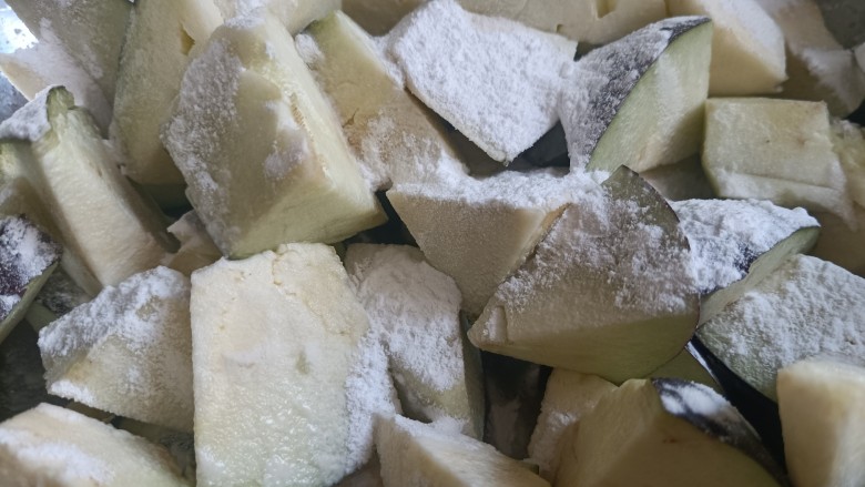 茄子盖浇饭,把茄子块装进盆里,少淋点水,少量多次的放入淀粉,一遍一遍的颠几下盆,让茄子均匀沾上淀粉