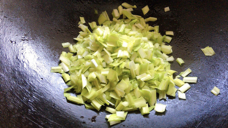 韭黄炒豆腐,锅烧热油,加入韭黄碎进行炒制