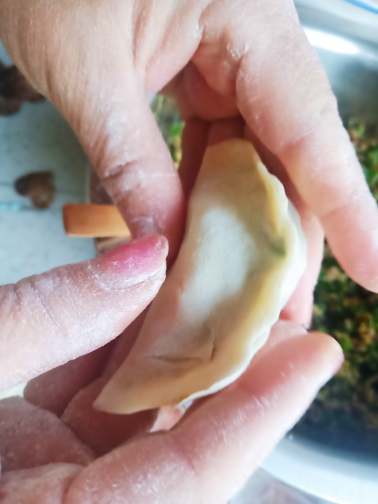 酸菜蒸饺,放入馅料,包成饺子。