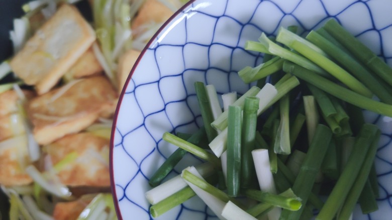 韭黄炒豆腐,炒至韭黄变软,加入小葱
