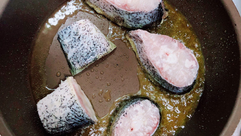 红烧鱼豆腐,锅中倒入油,加热至五成热,放入鱼块煎至焦黄。