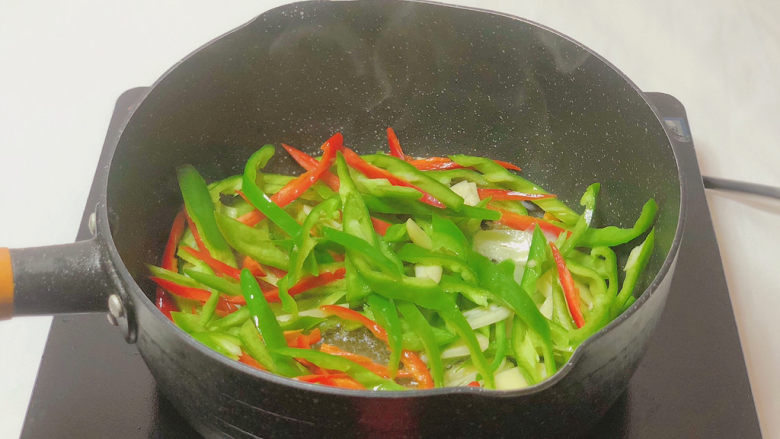 鸡枞菌炒肉,倒入切好的青红辣椒丝和大蒜片 翻炒均匀