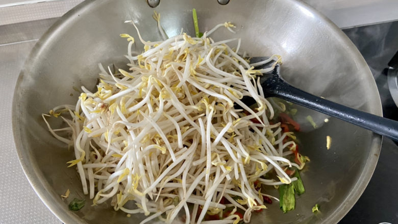 醋溜绿豆芽,转中大火,下绿豆芽,翻炒半分钟