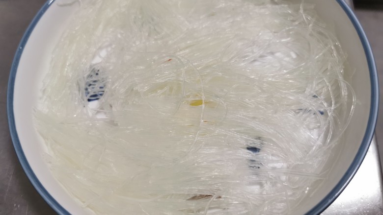 蒜蓉粉丝蒸丝瓜,泡软的粉丝剪开,铺在盘底