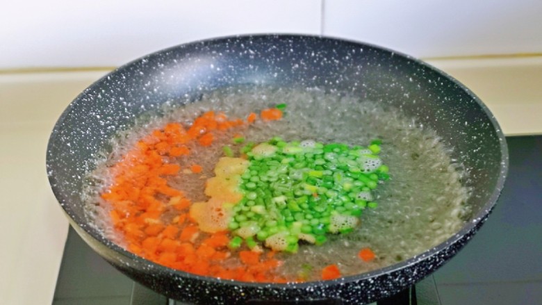 鸡蛋火腿炒饭,胡萝卜丁与蒜薹丁焯水: 锅中水烧开后,再下两丁大火煮1分钟捞出。
