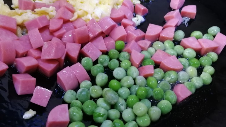 鸡蛋火腿炒饭,放入豌豆粒,文火翻炒半分钟。