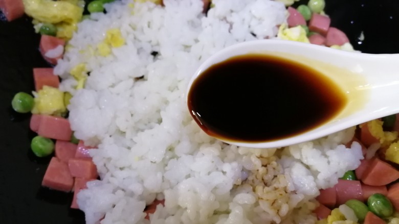 鸡蛋火腿炒饭,加<a style='color:red;display:inline-block;' href='/shicai/ 788'>生抽</a>提鲜,文火翻炒均匀。