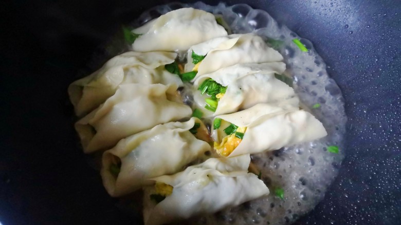 韭菜肉锅贴,小火煎至底部微黄,加入约1厘米高的开水,盖上锅盖,焖一会儿