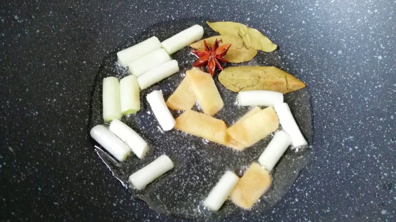西红柿土豆炖牛肉,炒锅内倒适量的食用油烧热,下入葱、姜、八角和香叶炒香。