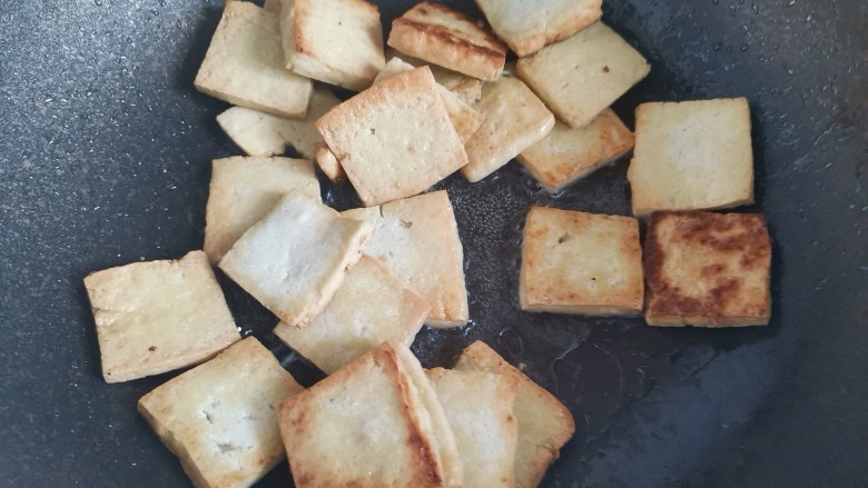 干煸豆腐,起锅烧油,下入豆腐小火煎至两面金黄盛出备用