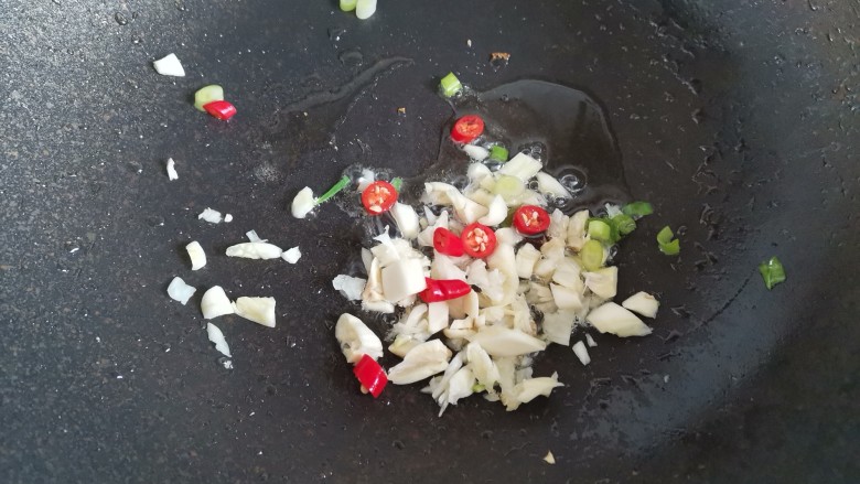 干煸豆腐,起锅烧油,下入葱蒜辣椒爆香