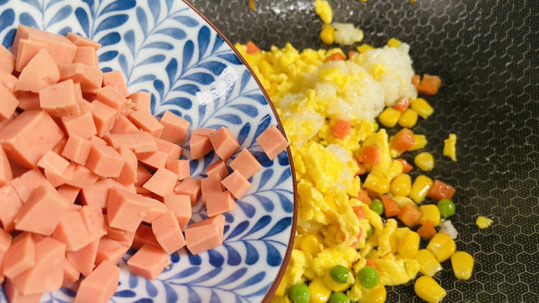 鸡蛋火腿炒饭,放入火腿丁翻炒均匀