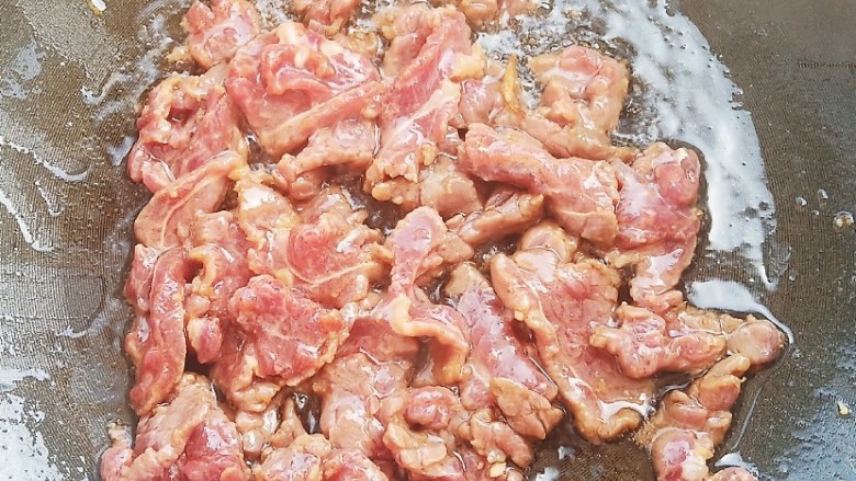 豆角牛柳,锅中烧油,加入牛肉快速翻炒变色后盛出备用。