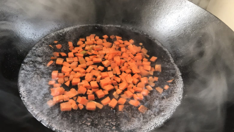 什锦香肠焖饭,锅中烧开水,放入胡萝卜煮沸