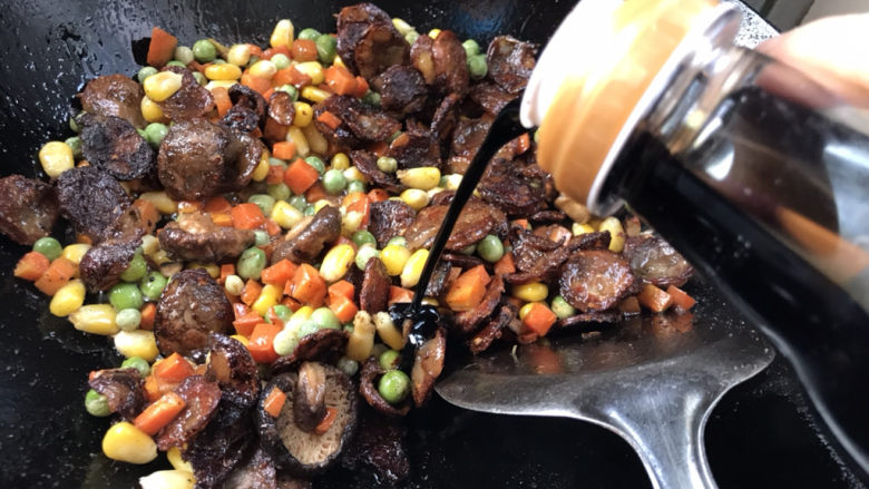 什锦香肠焖饭,淋入少许酱油,翻炒均匀