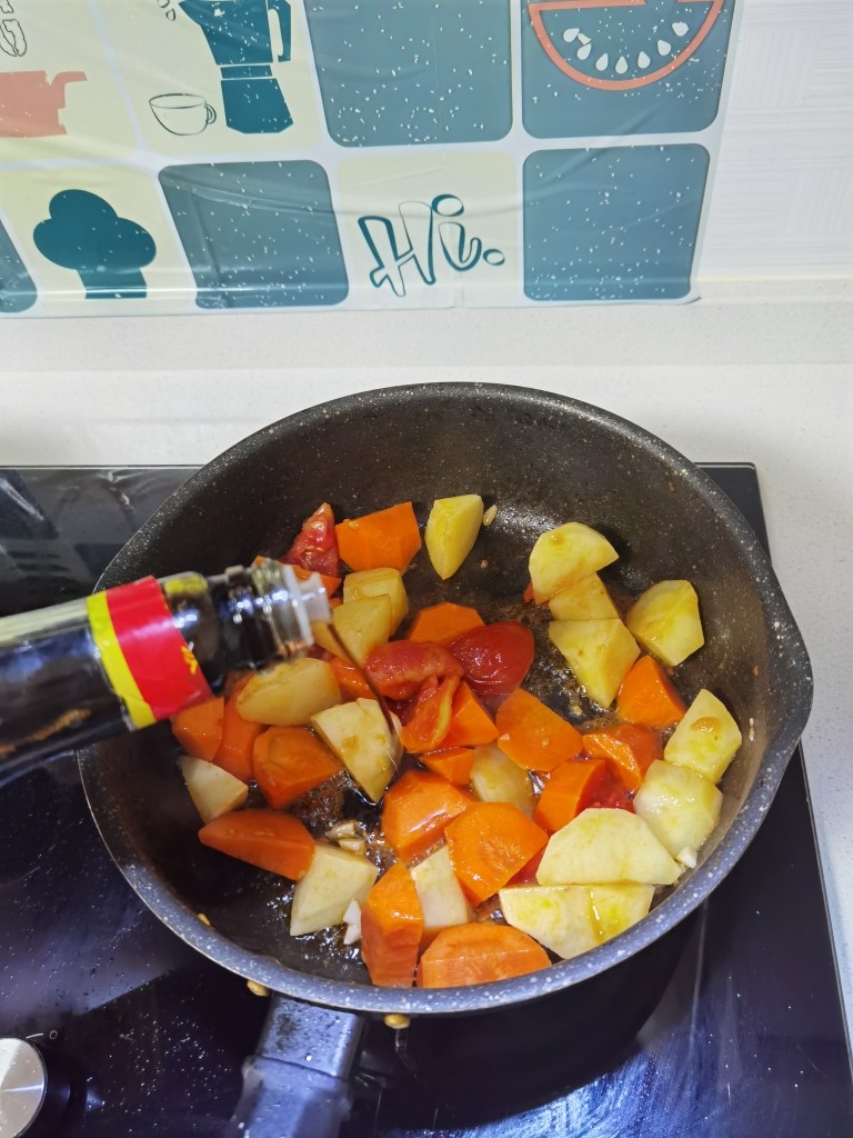 西红柿土豆炖牛肉,倒入土豆、胡萝卜翻炒,倒入生抽。