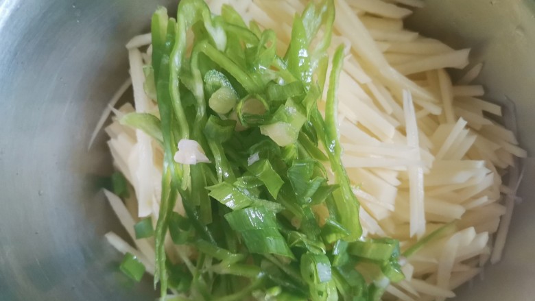 家常土豆饼,土豆装入盆中,加入青椒丝和葱花