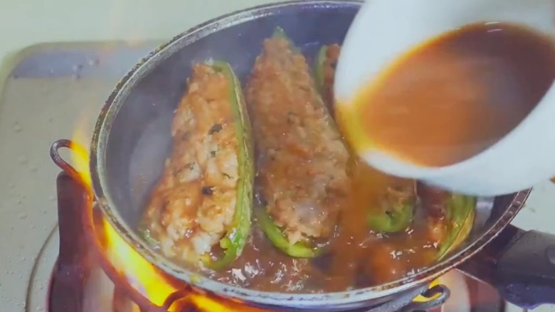 青椒酿肉,淀粉生抽调一个料汁倒入锅中,中火煮五分钟即可。