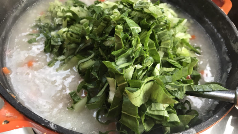胡萝卜肉末粥,接着加入青菜拌匀,大火煮沸