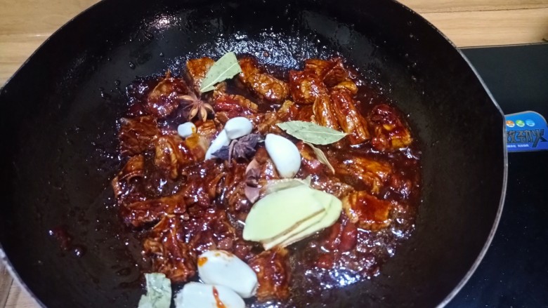 西红柿土豆炖牛肉,倒入大蒜头,生姜,八角香叶