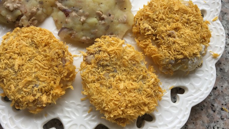 家常土豆饼,土豆饼先裹一层面粉,再裹鸡蛋,最后裹上面包糠,依次完成所有准备工作