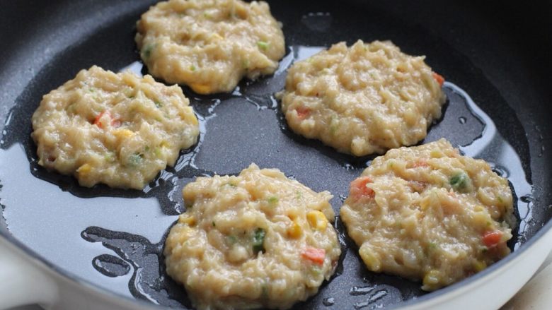 蔬菜鸡肉饼,平底不粘锅中倒适量食用油,用汤勺舀取适量肉糜放入锅中摊成饼状,形状也无需太规则。