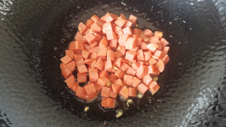 鸡蛋火腿炒饭,热油放入蒜末爆香,放入火腿炒片刻捞出